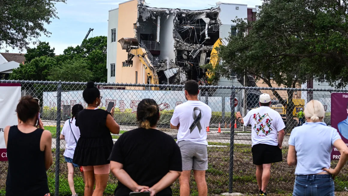 Spectators watch as crews begin demolition of the 1200 building at Marjory Stoneman Douglas High School on Friday.  Giorgio Viera/AFP/Getty Images