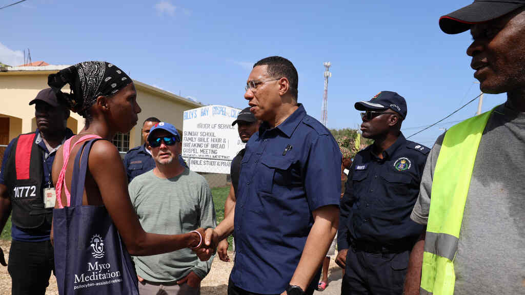 Prime Minister Andrew Holness (third right) greets a resident while touring sections of St Elizabeth the day after the passage of Hurricane Beryl.