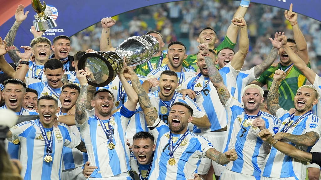 Argentina's Lionel Messi holds the trophy as he celebrates with teammates after defeating Colombia in the Copa America final in Miami Gardens, Fla., Monday, July 15, 2024. (AP Photo/Rebecca Blackwell).

