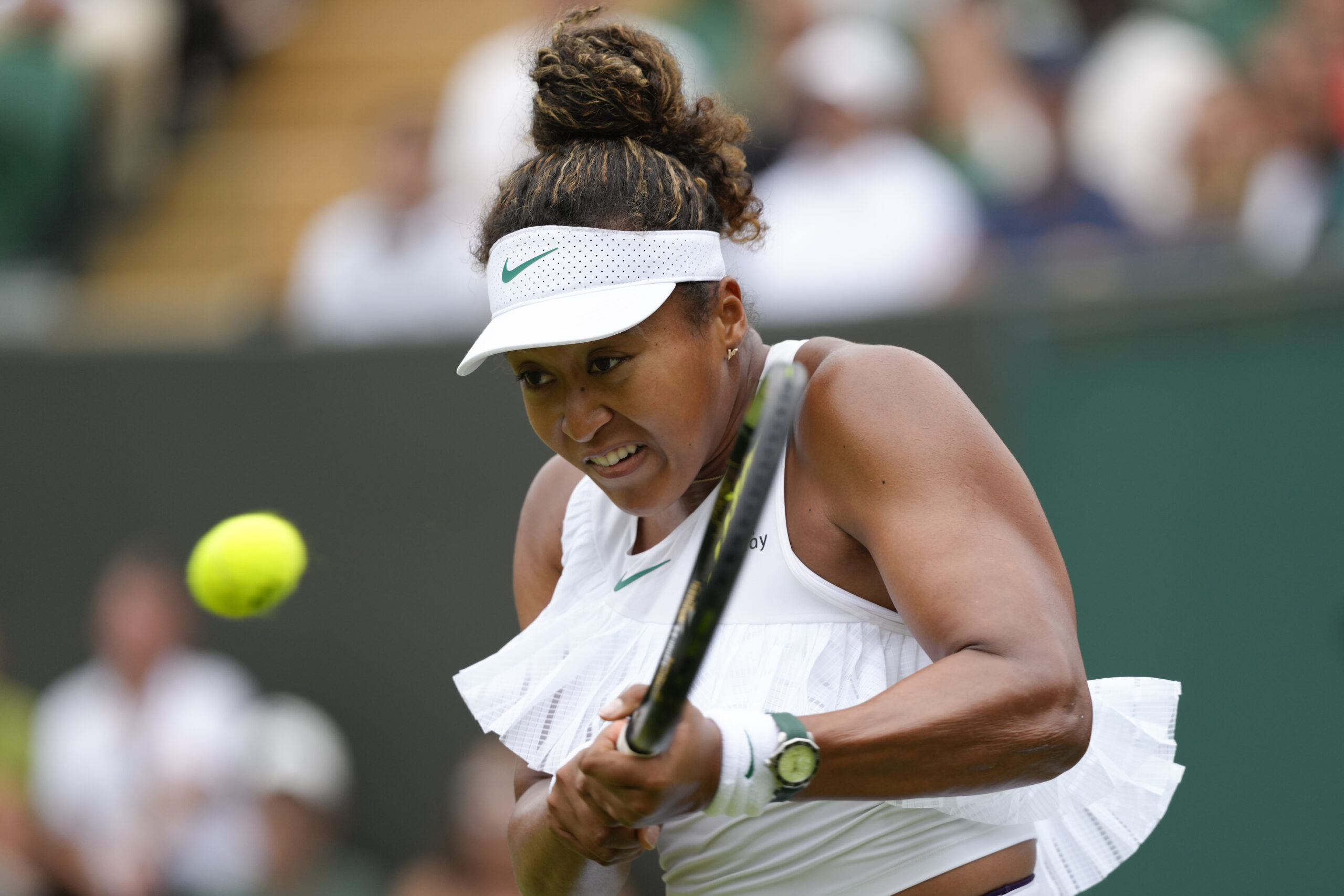 Naomi Osaka (Japan) plays a backhand return to Diane Parry (France) during their first round match at the Wimbledon tennis championships in London, Monday, July 1, 2024. (AP Photo/Kirsty Wigglesworth)