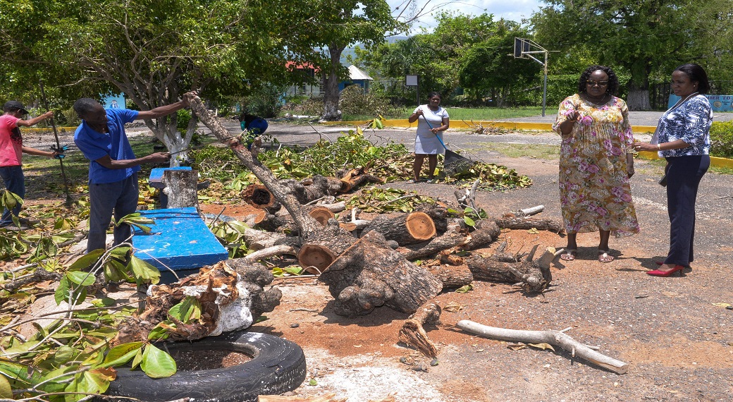 Principal of the Toll Gate Primary School, Rev. Carol Brown-Clarke (second right), makes a point to Education Officer at the Ministry of Education and Youth, Raquel Ranger Cowan (right), during the removal of debris from the school. 
