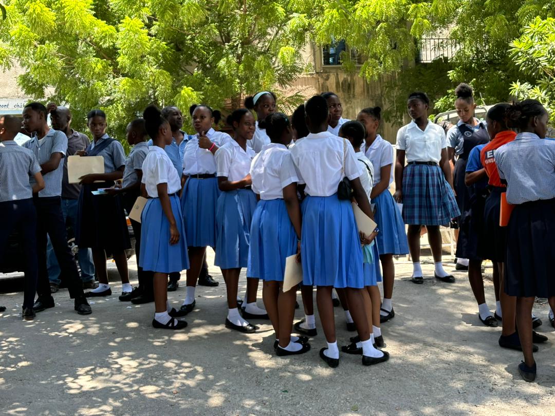 9th grade students chat in the courtyard of an examination center. Photo: Loop Haiti