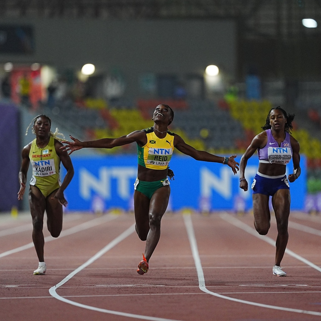 Alana Reid (centre) celebrates as she crosses the finish line to win the 100m at the 2024 World Athletics Under-20 Championships in Lima, Peru. (Photo: World Atheltics)  