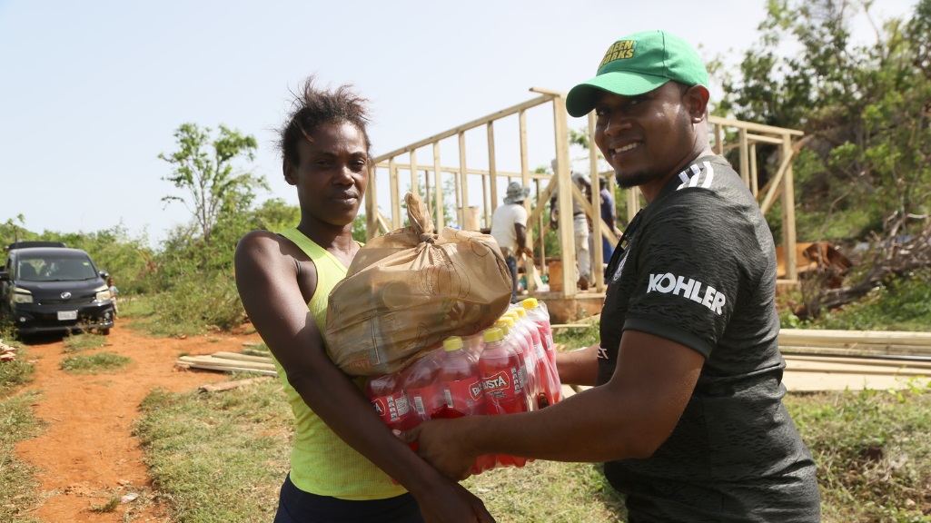 Roseann Crowe, mother of five who lost her house in Hurricane Beryl gratefully received a donation of Busta Soft Drinks on Saturday, from MP Floyd Green.