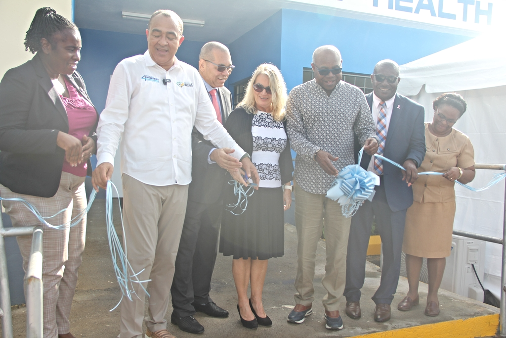 Minister of Health and Wellness, Dr. the Hon. Christopher Tufton (second left), cuts the ribbon to mark the official opening of the new $50 million Adelphi Health Centre, in St. James, on Thursday, October 17.