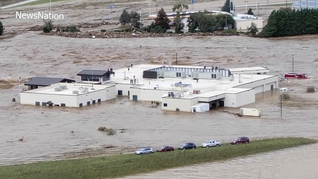 In this image made from a video provided by NewsNation, people can be seen on the roof of the Unicoi County Hospital in Erwin, Tenn., on Friday, Sept. 27, 2024. (NewsNation via AP)
