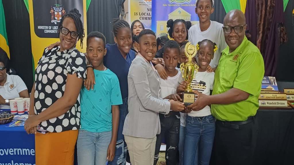 Literacy specialist at Falmouth All-Age School, Nardia Malcolm Witter, and students receive the winning trophy for the Trelawny Municipal Corporation's Primary School Poetry  Competition from Falmouth Mayor, Collen Gager, on Wednesday in Falmouth, Trelawny.