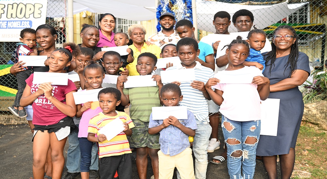 Mayor of Montego Bay and Chairman of the St James Municipal Corporation, Councillor Richard Vernon (back, centre); philanthropist, Sandra Miller-Hall (fourth left, back row); Shelter Manager of the Refuge of Hope, Junice Woolery-Norman (right), with children of Albion, St James, during an outreach at the Refuge of Hope shelter.