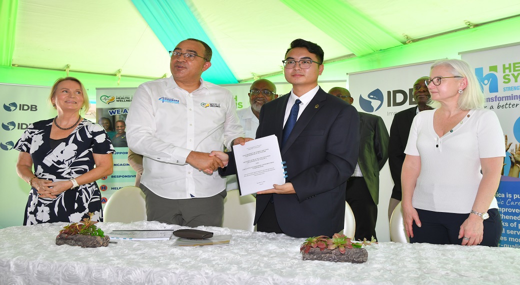 Minister of Health and Wellness, Dr Christopher Tufton (2nd left), and General Manager of China Civil Engineering Construction Corporation, Junyi  Wang (2nd right), shake hands as they display the signed contract for the $660 million expansion of the Greater Portmore Health Centre. Looking on (from left) are European Union Ambassador (EU) to Jamaica, Her Excellency, Dr Erja Askola; and Country Representative for the Inter-American Development Bank (IDB), Natacha Marzolf.