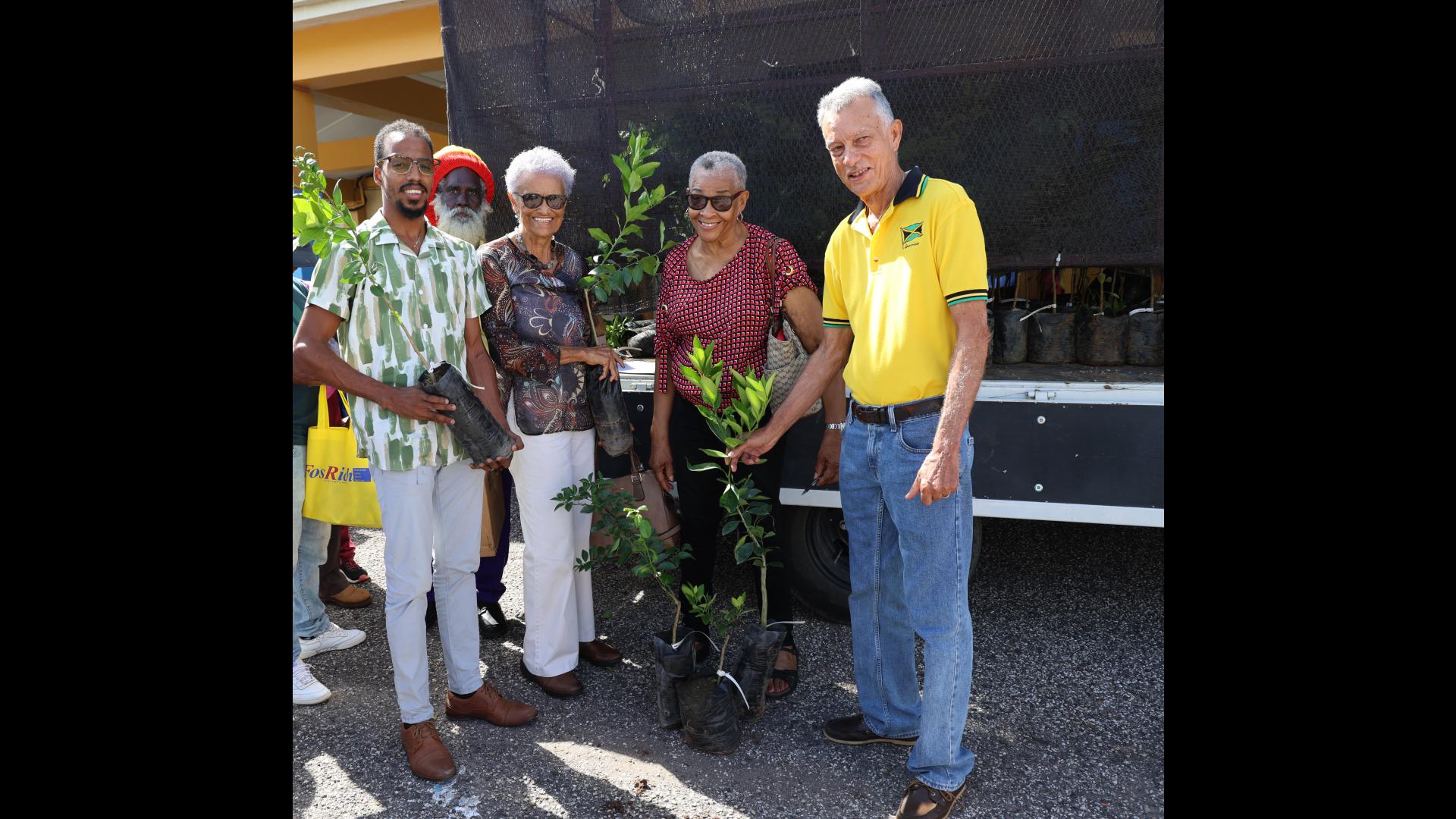 Chairman of the Manchester Parish Development Committee (PDC), Anthony Freckleton (right), and Nursery Manager at the Jamaica Bauxite Institute (JBI), Chevion Morgan (left), recently hand out citrus seedlings to householders at the recent staging of Manchester Community Day at the Northern Caribbean University (NCU) in Mandeville.