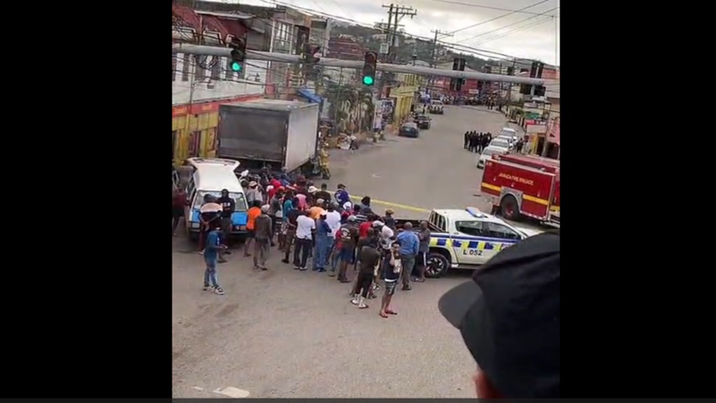 A screengrab from a video of the scene outside a building in the town of Spaldings on the border of Manchester and Clarendon where a group of gunmen barricaded themselves inside a business establishment fo hours on Sunday afternoon after being cornered and challenged by the police who were responded to an armed robbery and the shooting of a police officer in the town.