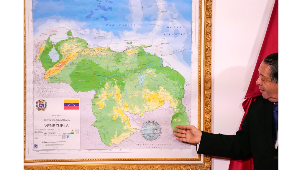 FILE - Chairman of the Special Commission for the Defense of Guyana Essequibo Hermann Escarra, stands next to Venezuela's new map that includes the Essequibo territory, a swath of land that is administered and controlled by Guyana but claimed by Venezuela, during an unveiling ceremony in Caracas, Venezuela, December 8, 2023. (AP Photo/Matias Delacroix, File)
