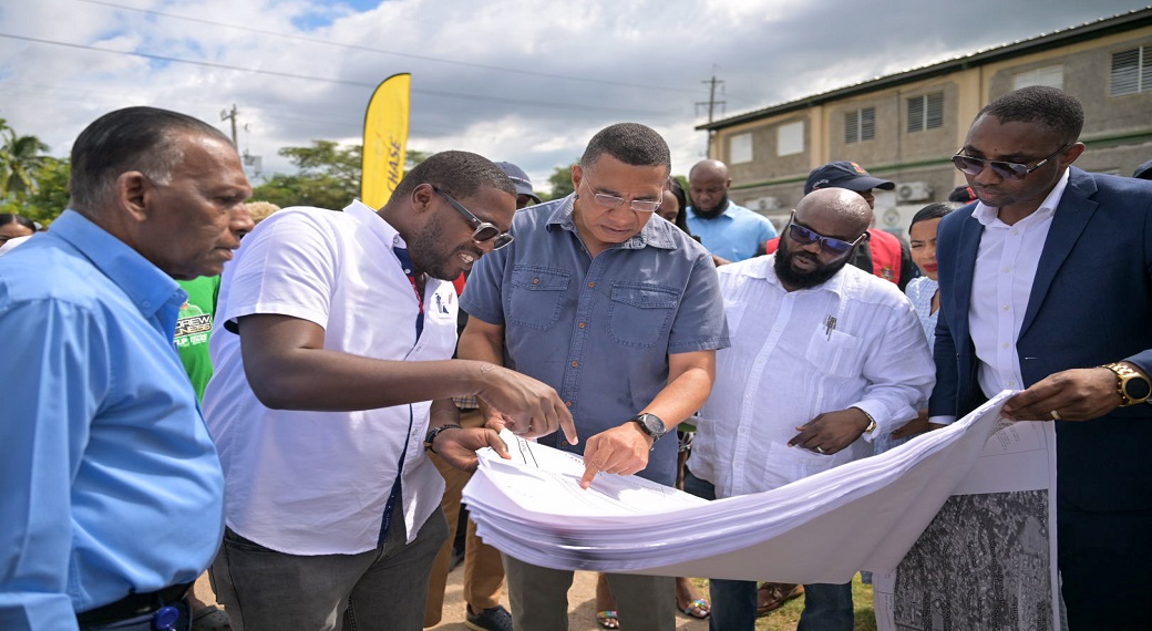 Prime Minister, Andrew Holness (centre), examines the architectural plan for the approximately $127-million Olympic Way Cultural Community Centre with Engineering Consultant, Theodore Wint (second left), and Managing Director, C&D Construction and Engineering Limited, Clive Wint (third right), during the official groundbreaking ceremony at the project site, located at 119B Olympic Way, St Andrew. They are joined by (from left) Culture, Health, Arts, Sports and Education (CHASE) Fund Chief Executive Officer,