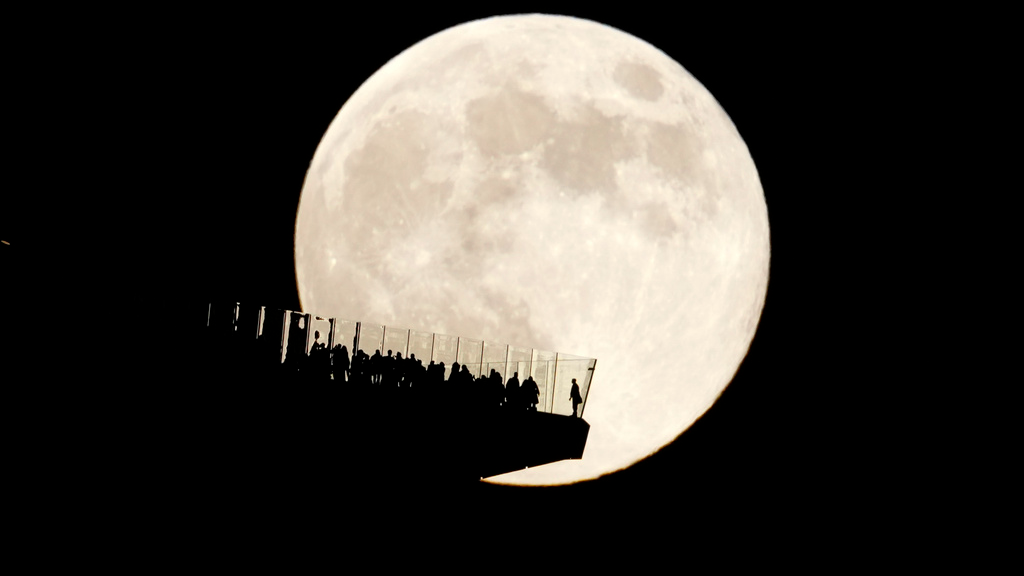 FILE - A supermoon rises behind an observation deck in New York City as seen from Hoboken, N.J., Friday, Nov. 15, 2024. (AP Photo/Seth Wenig, File)