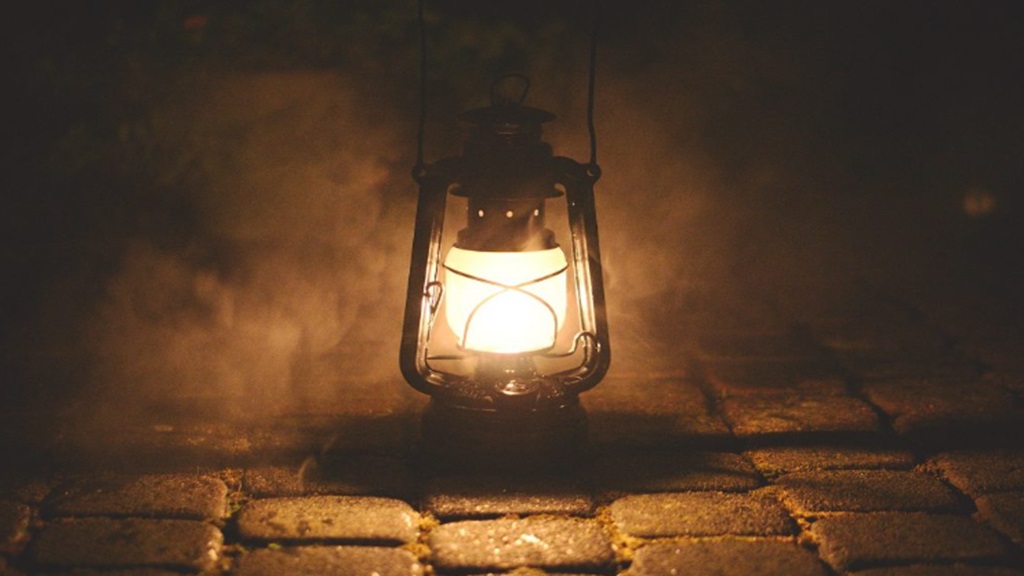 A photo of a kerosene lamp in nightime use.