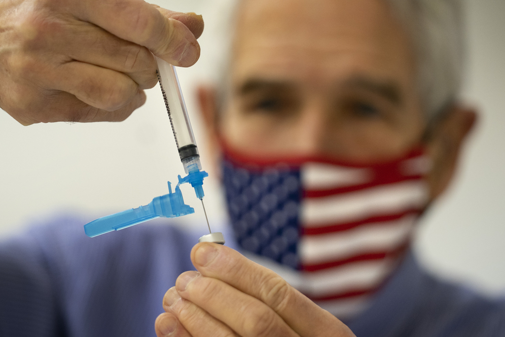 FILE - Dr. Sydney Sewall fills a syringe with the COVID-19 vaccine at the Augusta Armory, Dec. 21, 2021, in Augusta, Maine. (AP Photo/Robert F. Bukaty, File)
