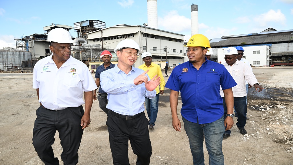 Minister of Agriculture, Fisheries and Mining, Hon. Floyd Green (right), and State Minister in the Ministry, Hon. Franklin Witter (left), listen to a point from Pan Caribbean's Chairman and Chief Executive Officer (CEO), Zudui Zhang, during a tour of the Frome Sugar Factory in Westmoreland on Wednesday (January 8). - Okoye Henry Photos