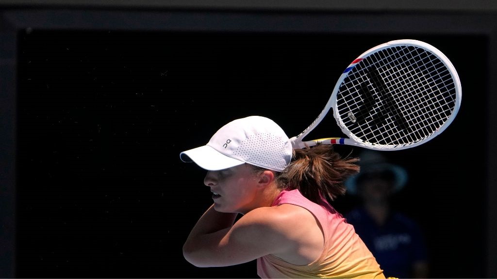 Iga Swiatek of Poland plays a backhand return to Rebecca Sramkova of Slovakia during their second round match at the Australian Open tennis championship in Melbourne, Australia, Thursday, Jan. 16, 2025. (AP Photo/Asanka Brendon Ratnayake).