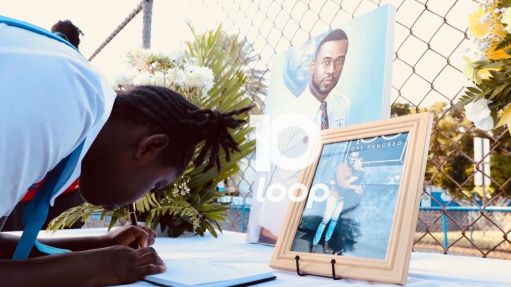 Six grader Arielle Kerr at Jessie Ripoll Primary, signs the condolence book at devotion on Tuesday at the Camp Road-based school in Kingston following the passing of the principal O’Neil Stevens and his wife Camesha Lindsay Stevens. (Photo: Marlon Reid)