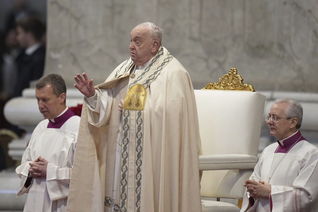 Pope Francis is flanked by Vatican Head Master of Ceremonies, Bishop Diego Giovanni Ravelli, right, and Master of Ceremonies, Bishop Krysztof Marcjanowicz as he presides over a mass in St. Peter's Basilica at The Vatican on New Year's Day, Wednesday, Jan. 1, 2025. (AP Photo/Andrew Medichini)
