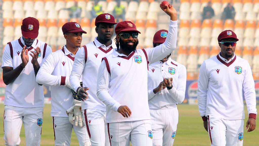 West Indies Jomel Warrican, centre, who took seven wickets in the second innings, raises the ball to acknowledge the crowd during the day three of the first test cricket match against Pakistan in Multan, Pakistan, Sunday, Jan. 19, 2025. (AP Photo/Asim Tanveer).