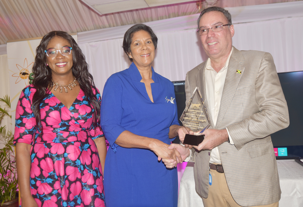  Professor Alison Nicholson (centre) receives her award from Science and Technology Minister Daryl Vaz. Sharing in the moment is Executive Director, SRC, Dr Charah 
Watson.