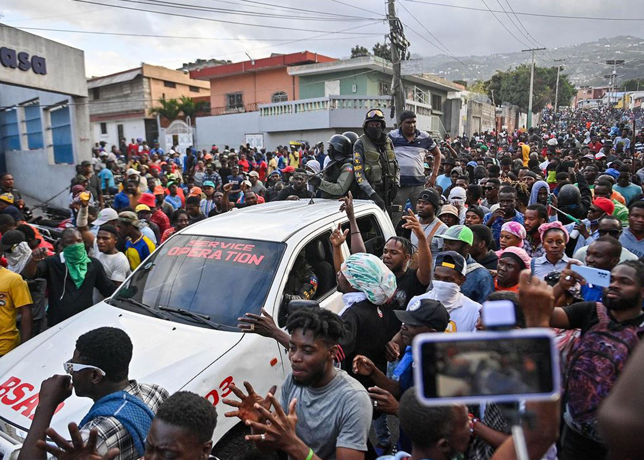 Des manifestants à Port-au-Prince le 6 février 2024 ont accueilli avec enthousiasme l'arrivée de la Brigade de Sécurité des Aires Protégées (BSAP), tout en exigeant le départ du Premier ministre haïtien Ariel Henry. Le gouvernement a annoncé le 5 février 2024 une répression contre la BSAP, critiquée pour ses affrontements violents avec la police. Richard PIERRIN / AFP