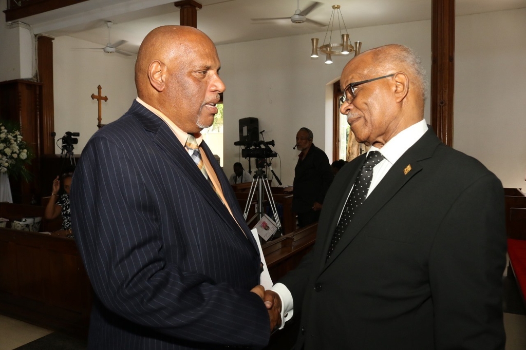Former Governor General of Jamaica Sir Kenneth Hall (right) greets Michael Erskine.