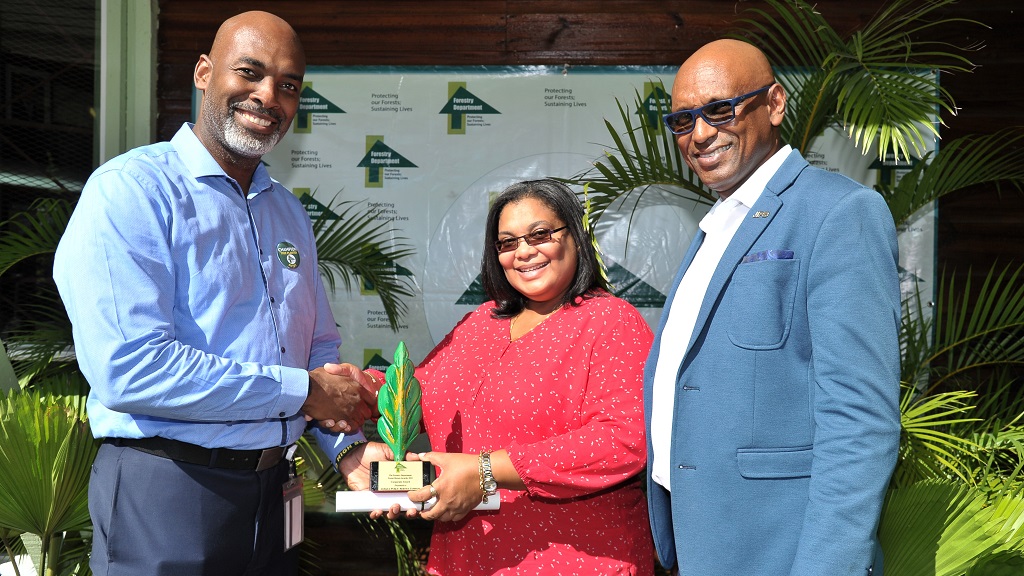 cameroon timber CEO and Conservator of Forests, Ainsley Henry (left) presents the Corporate Forest Heroes Award and citation to JPS Manager for Environment, Health, and Safety, Azalee Lawson. Sharing in the moment is JPS Senior Vice President, Joseph Williams.