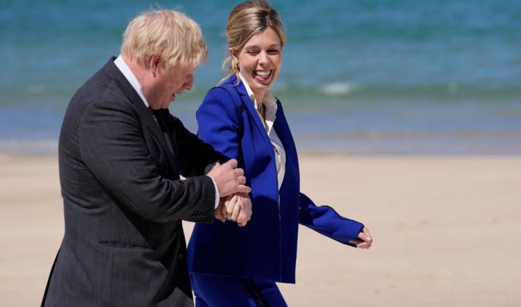 在这张摄于2021年6月12日(周六)的资料照片中，英国首相鲍里斯·约翰逊和妻子凯莉在英国圣艾夫斯举行的七国集团峰会上走在木板路上，准备迎接客人。凯莉·约翰逊在Instagram上发帖称，再次怀孕让她感到“无比幸福”，她期待着这对夫妇的第二个孩子。(美联社图片/Kirsty Wigglesworth, FILE)